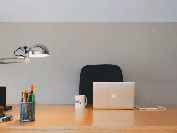 Office desk with laptop, mug, and stationery in South Africa.